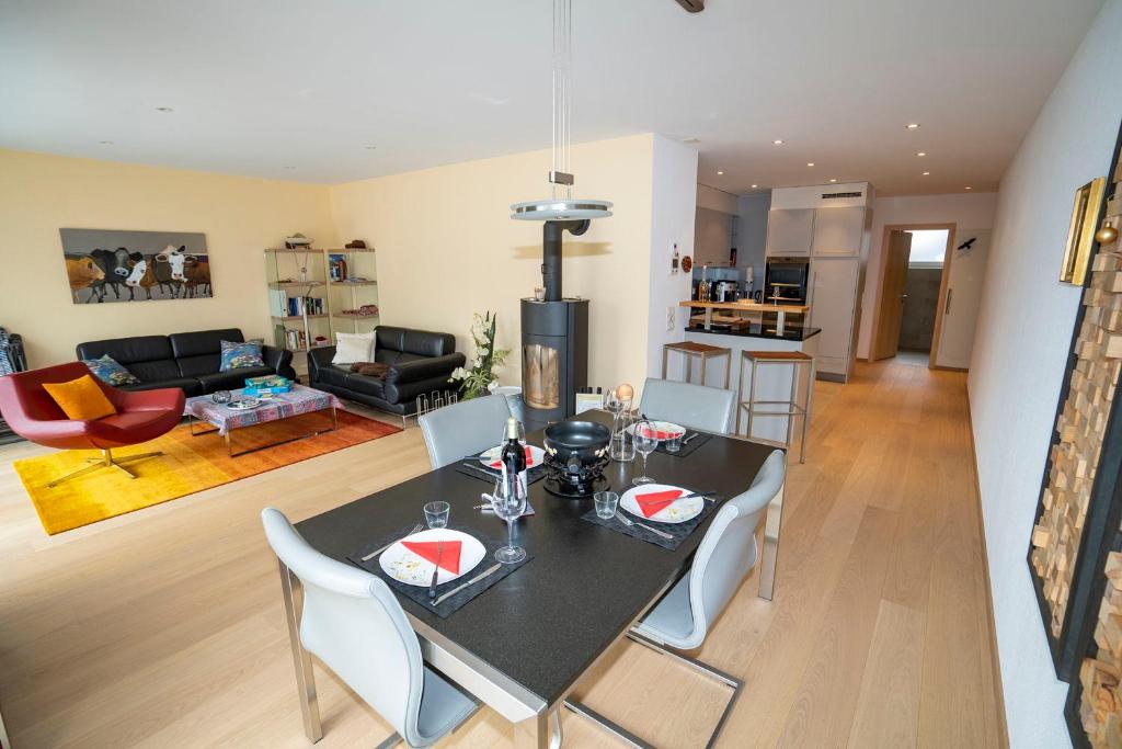 a dining room and living room with a table and chairs at Chasa Miramunt 6 in Scuol