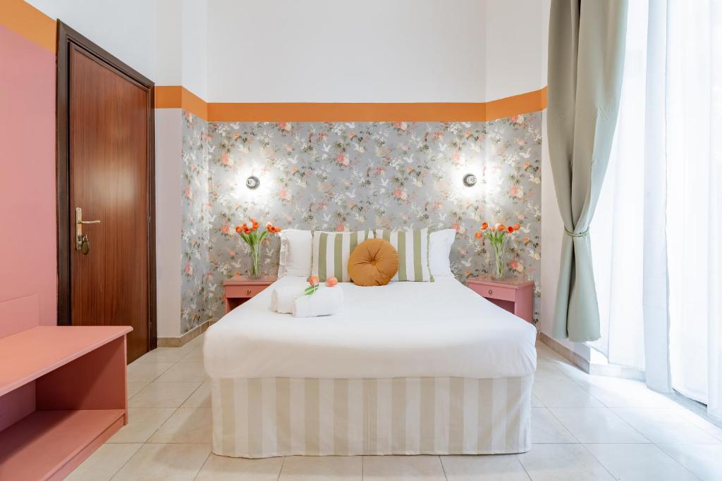 a bedroom with a white bed with flowers on the wall at Hotel Espana - Gruppo BLAM HOTELS in Rome