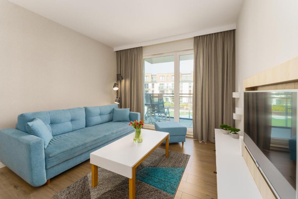 a living room with a blue couch and a table at Bel Mare 210C by Renters in Międzyzdroje