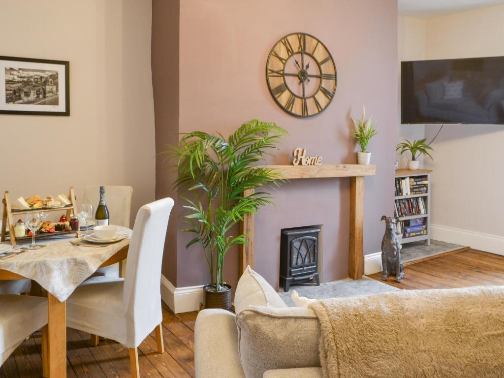 a living room with a table and a fireplace at Baekere House Apartment in Alnwick