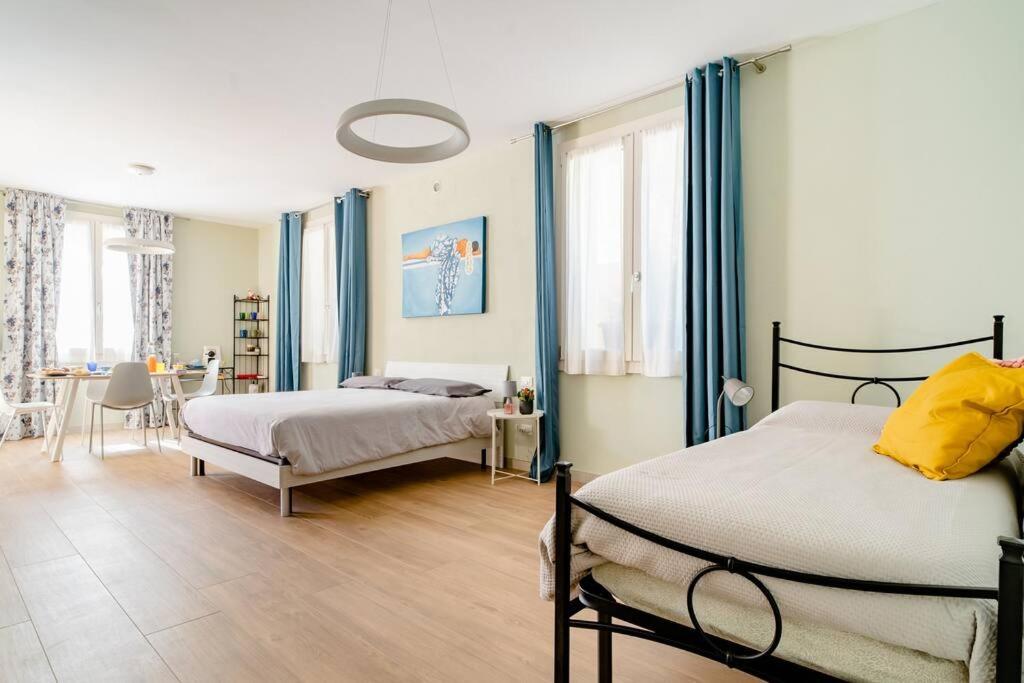 a bedroom with two beds with blue curtains and a table at B&B Franciacorta Rodengo Saiano in Rodengo Saiano