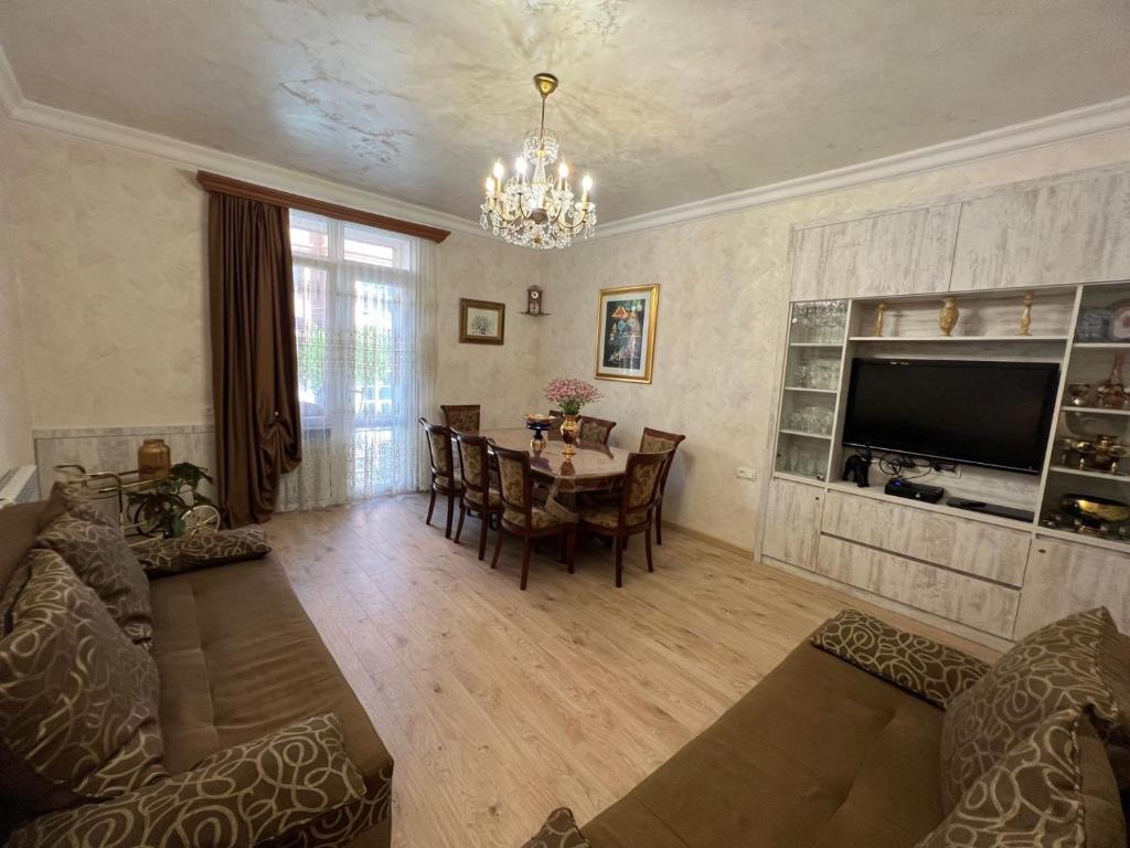 sala de estar con mesa y TV en Hanrapetutyan Apartment, en Ereván