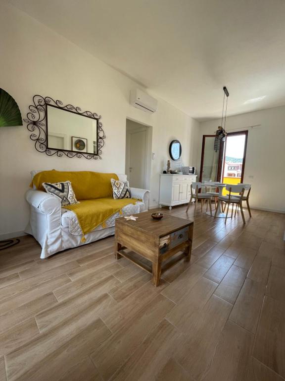 ein Wohnzimmer mit einem Sofa und einem Tisch in der Unterkunft Mareblu Simius in Villasimius