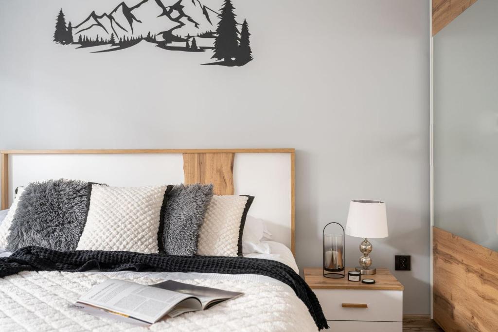 a bedroom with a bed with a mountain decal on the wall at Apartamenty Rodzinne ApartZakop in Zakopane