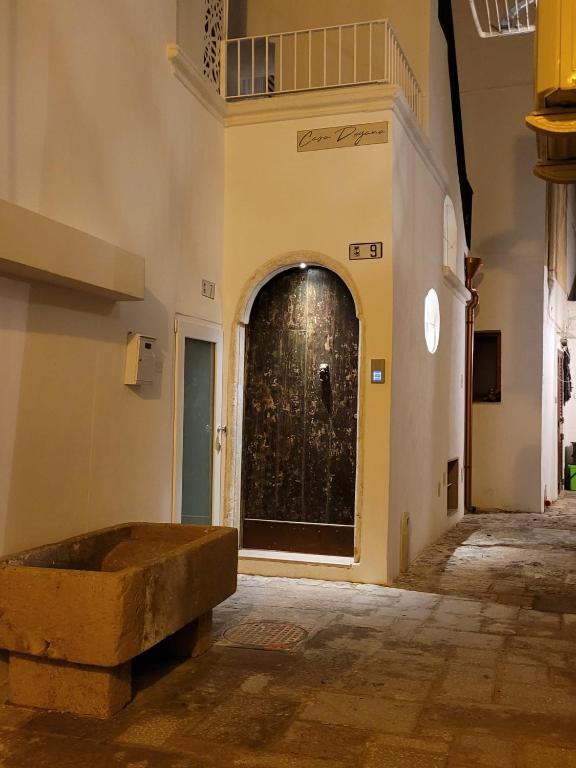a door in a building with a stone bench in front at Casa Dogana Apartment in Gallipoli