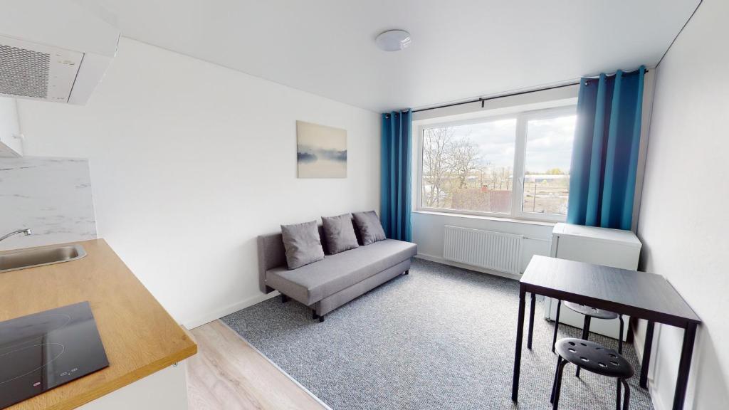 - un salon avec un canapé et une table dans l'établissement Kivi Apartments, à Jõhvi