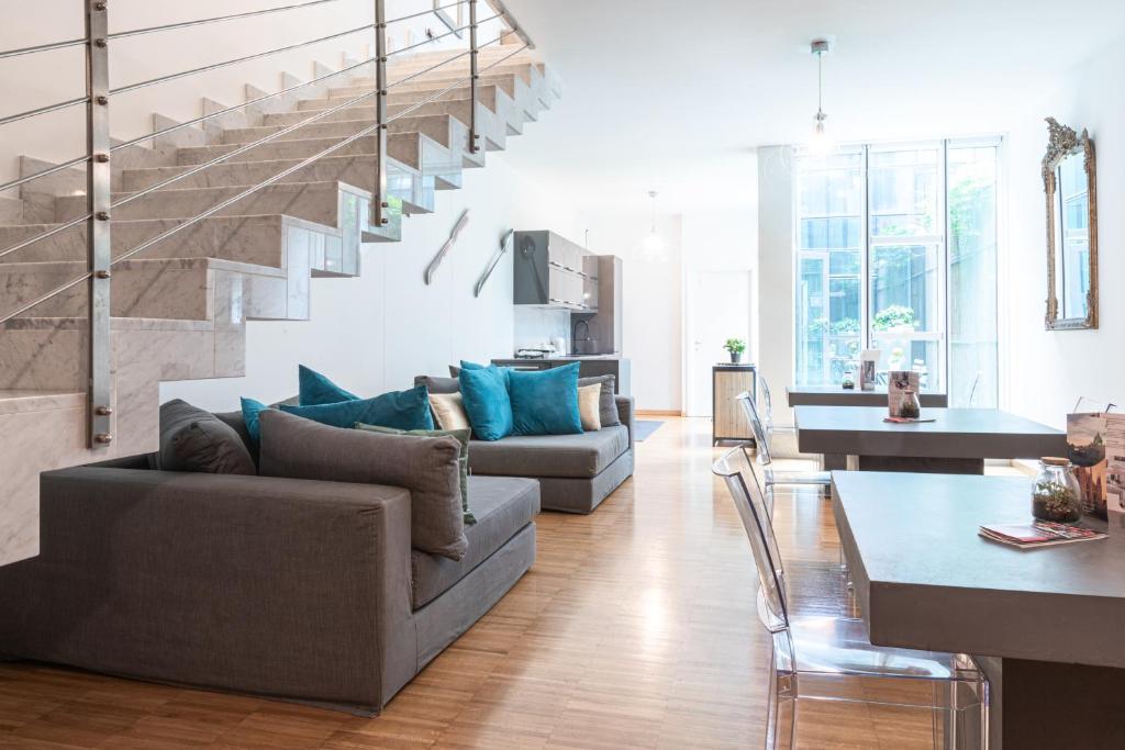 a living room with a couch and a staircase at Città Studi Suites - Top Collection in Milan