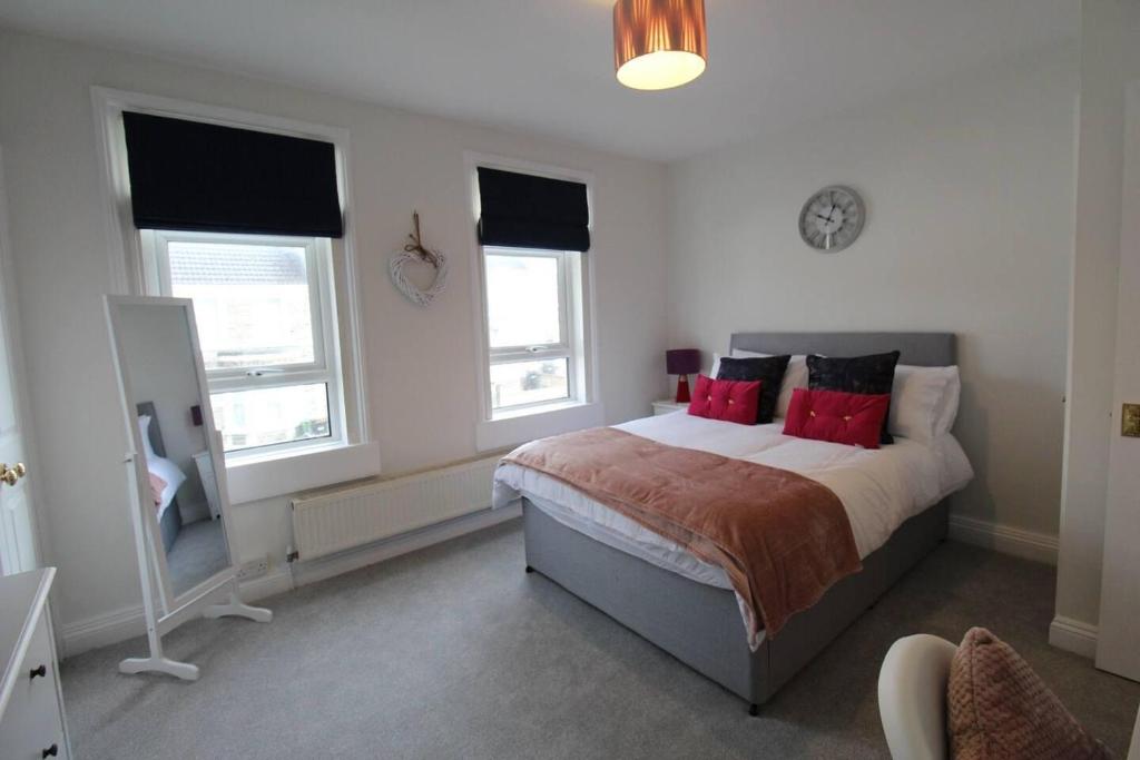 a bedroom with a large bed with red pillows at Remarkable 3-Bed House in Bath in Bath
