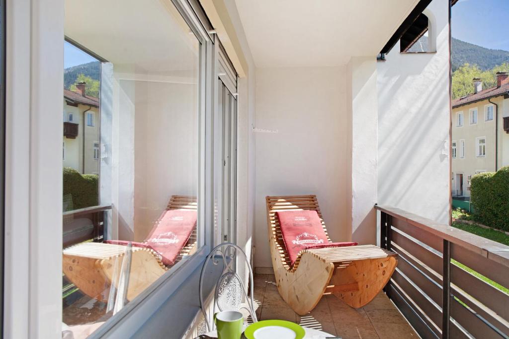 einen Balkon mit 2 Stühlen und einem großen Fenster in der Unterkunft Berghex in Garmisch-Partenkirchen