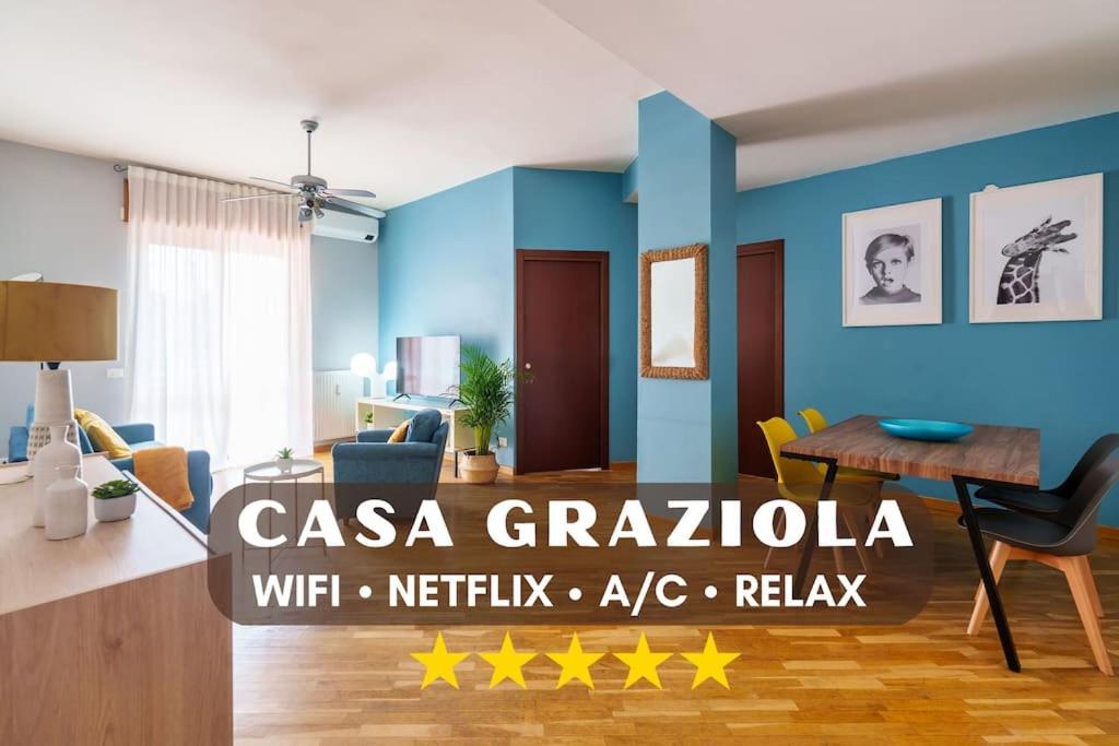 [Casa Graziola] Wi-Fi, Netflix, 5* Comfort في Gaggiano: غرفة معيشة بجدران زرقاء وطاولة وكراسي