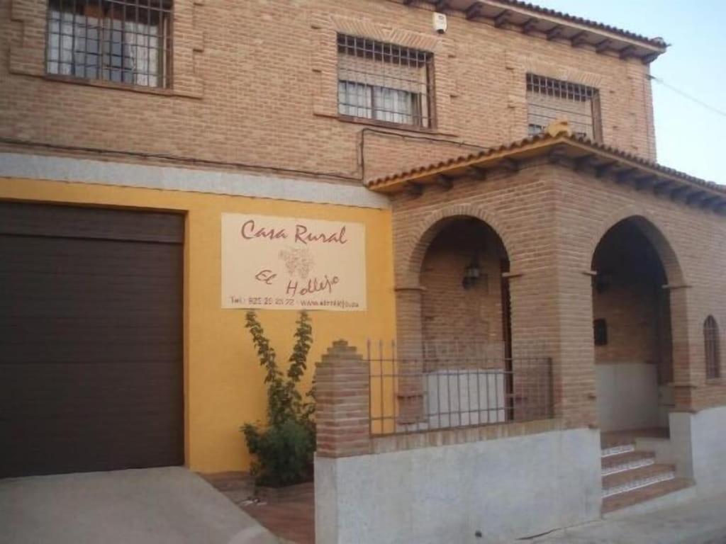 una casa de ladrillo con un garaje y un cartel en ella en Casa Rural El Hollejo, en Pulgar
