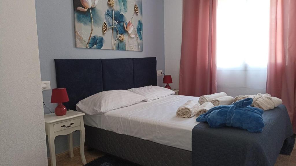 een slaapkamer met een bed met handdoeken erop bij Karina Apartaments in Torrevieja