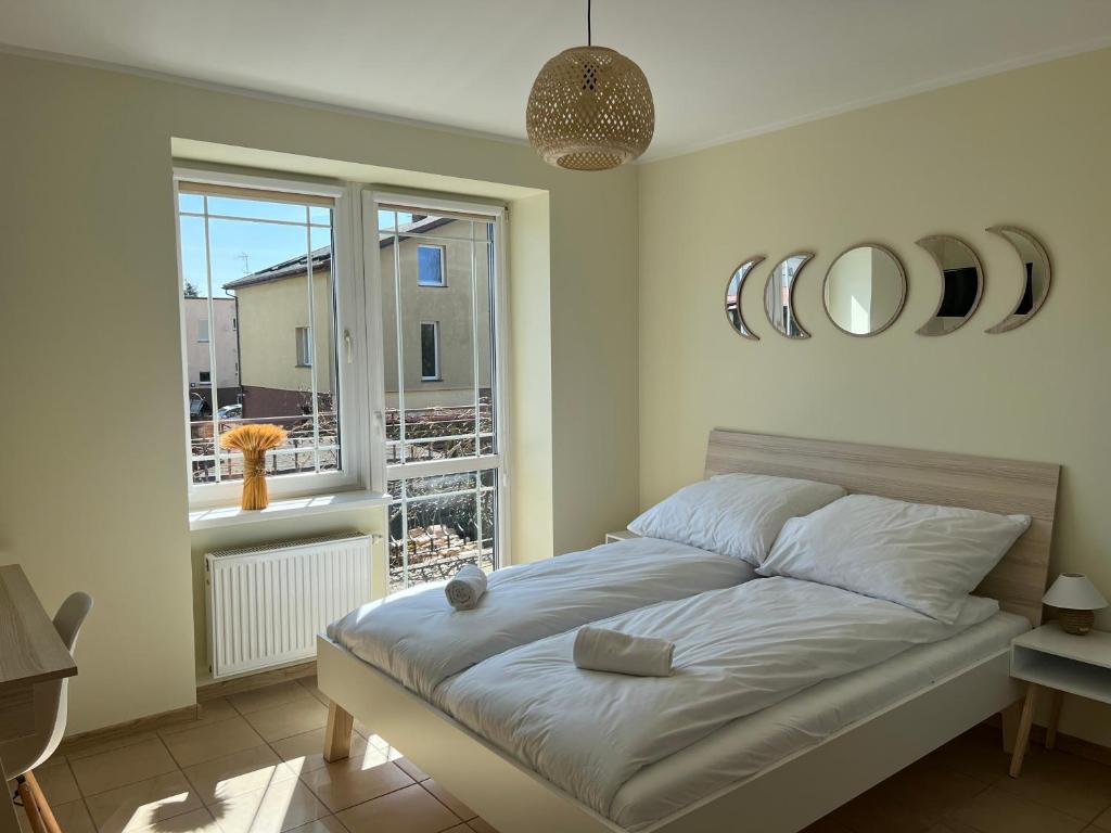 ein Schlafzimmer mit einem Bett und einem großen Fenster in der Unterkunft Wilczy Zaułek in Mielno