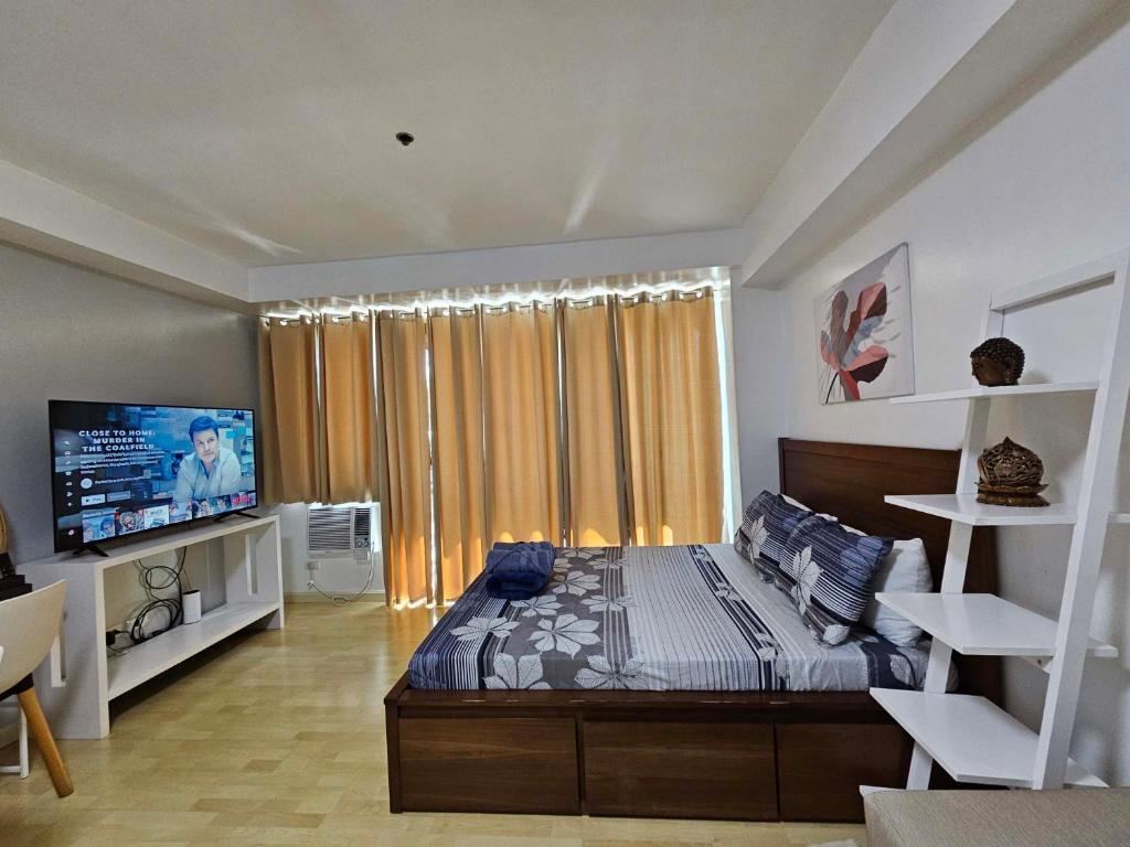 - une chambre avec un lit et une télévision dans l'établissement N place at Soho Central, à Manille