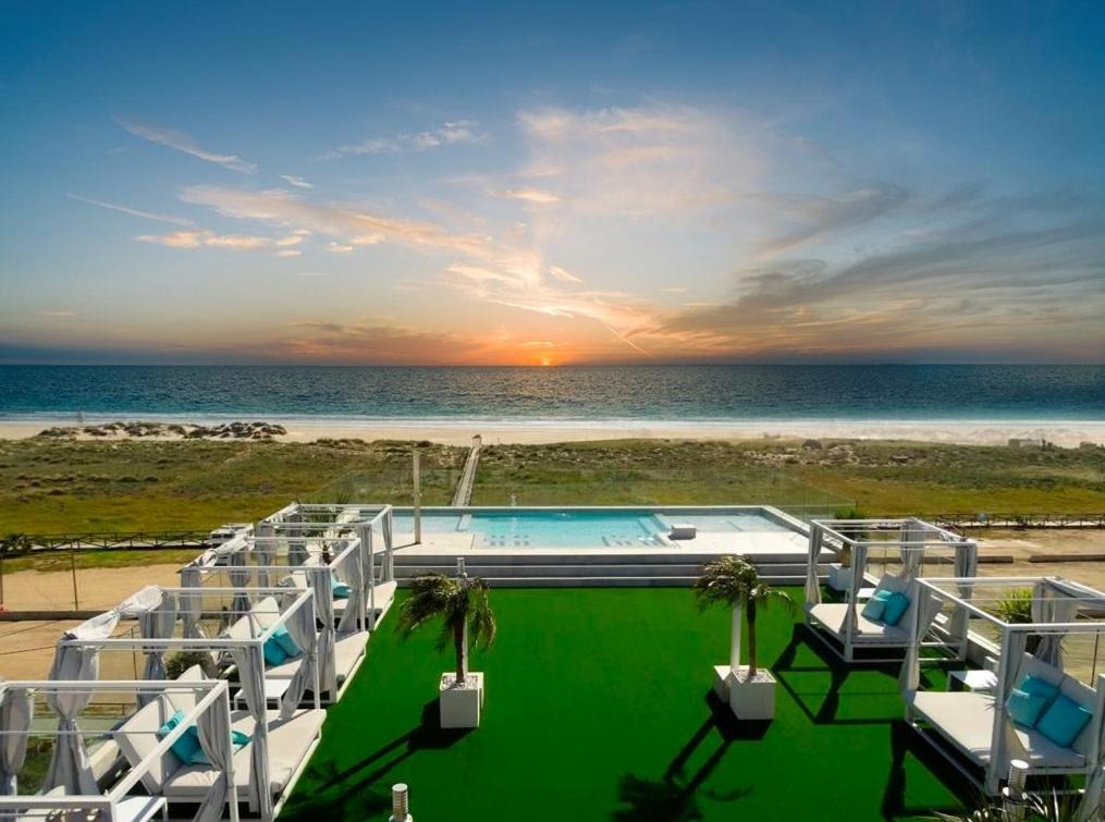 a swimming pool with a view of the beach at Hotel Pozo del Duque in Zahara de los Atunes