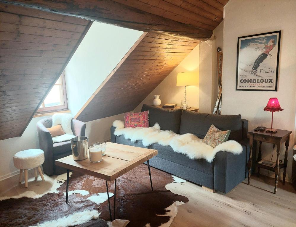 a living room with a blue couch and a table at Chalet charm in the heart of the old town - 40m2 in Annecy