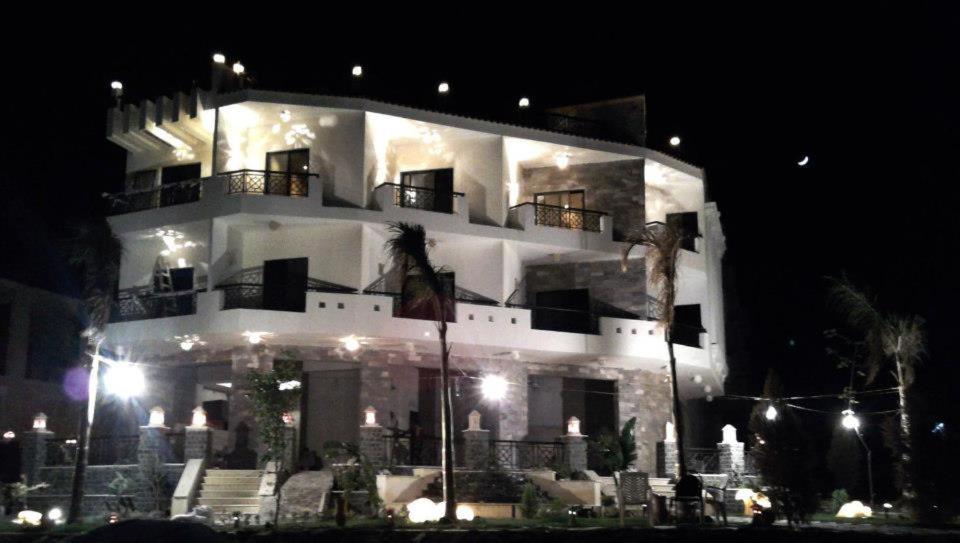 a large white building at night with lights at sea view house in Marsa Alam City