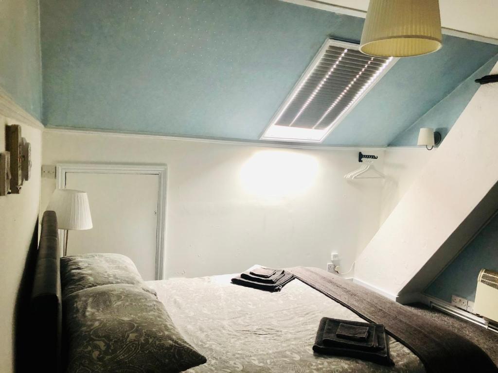 een slaapkamer met een bed en een plafondventilator bij AC Hideout in Rochford