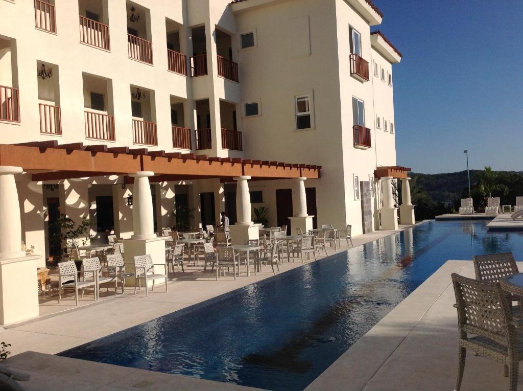 un hôtel avec une piscine en face d'un bâtiment dans l'établissement Mansiones Cruz del Mar, à Santa Cruz Huatulco