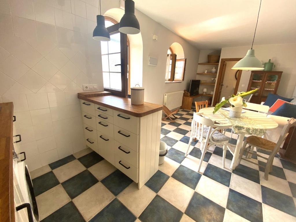 a kitchen with a checkered floor and a dining room at Casuca El Trisquel - 18002 in Bareyo