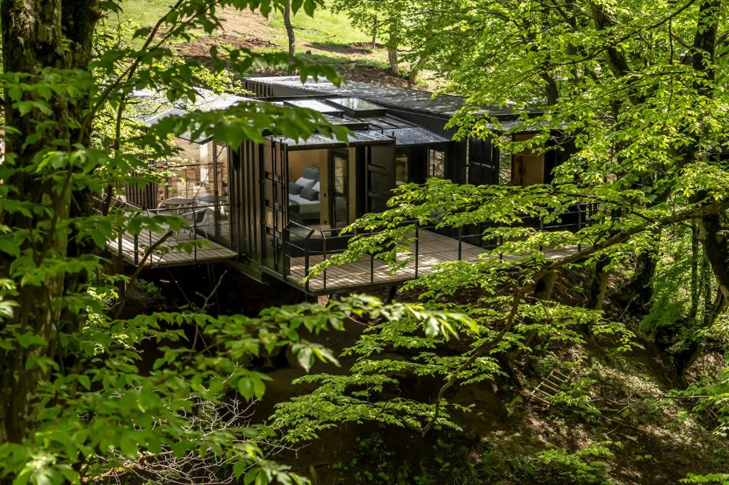 a house in the woods with a deck at Kiketi Farm Container in Kiketʼi