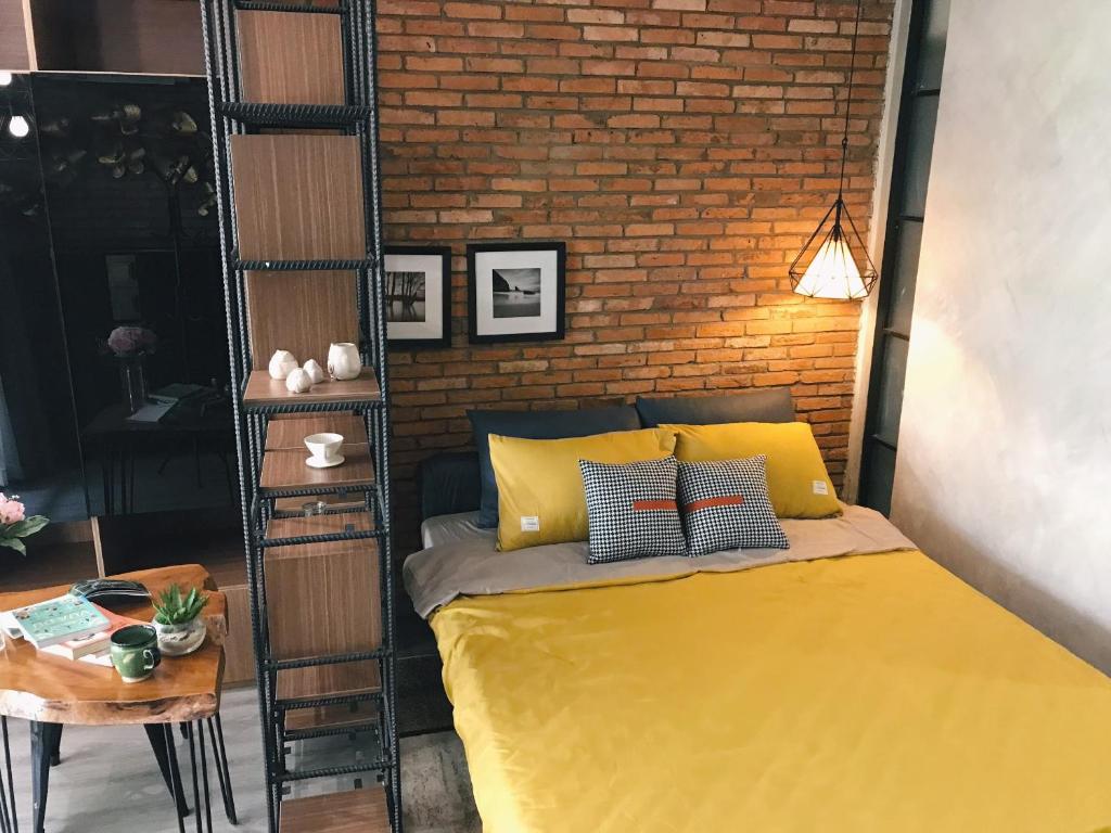 um quarto com uma cama amarela e uma parede de tijolos em Sweetheart in Saigon em Ho Chi Minh