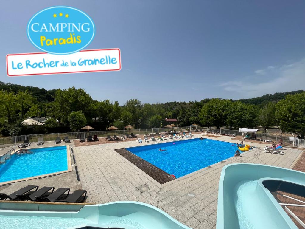 una piscina en un complejo con gente sentada alrededor en Camping Paradis le Rocher de la Granelle en Le Bugue