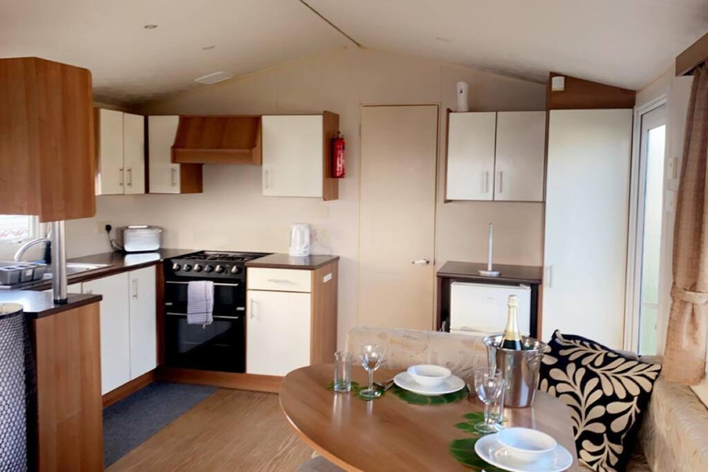 a kitchen with a table and a kitchen with a stove at Whitley bay caravan retreat in Whitley Bay