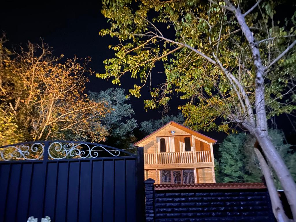 una casa de madera detrás de una valla por la noche en Villa ,,GELATI'', en Motsameta