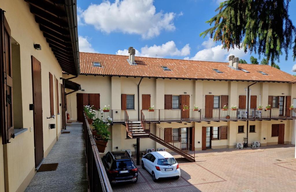 a building with two cars parked in a courtyard at Residence il Cascinetto in Pavia