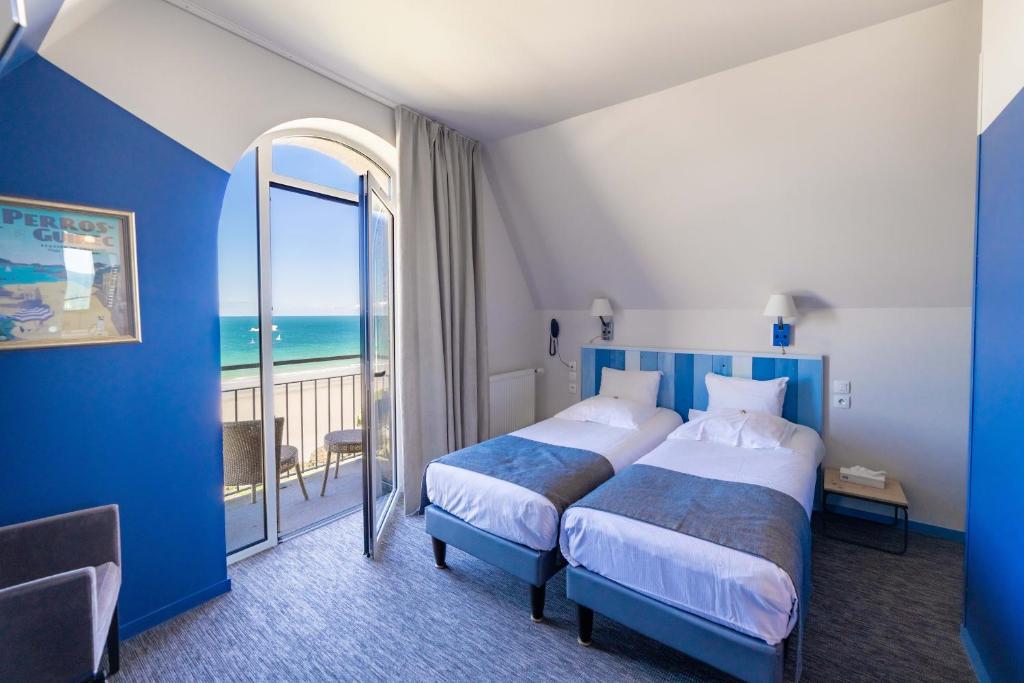um quarto de hotel com duas camas e vista para o oceano em Logis Hôtel Ker Mor em Perros-Guirec