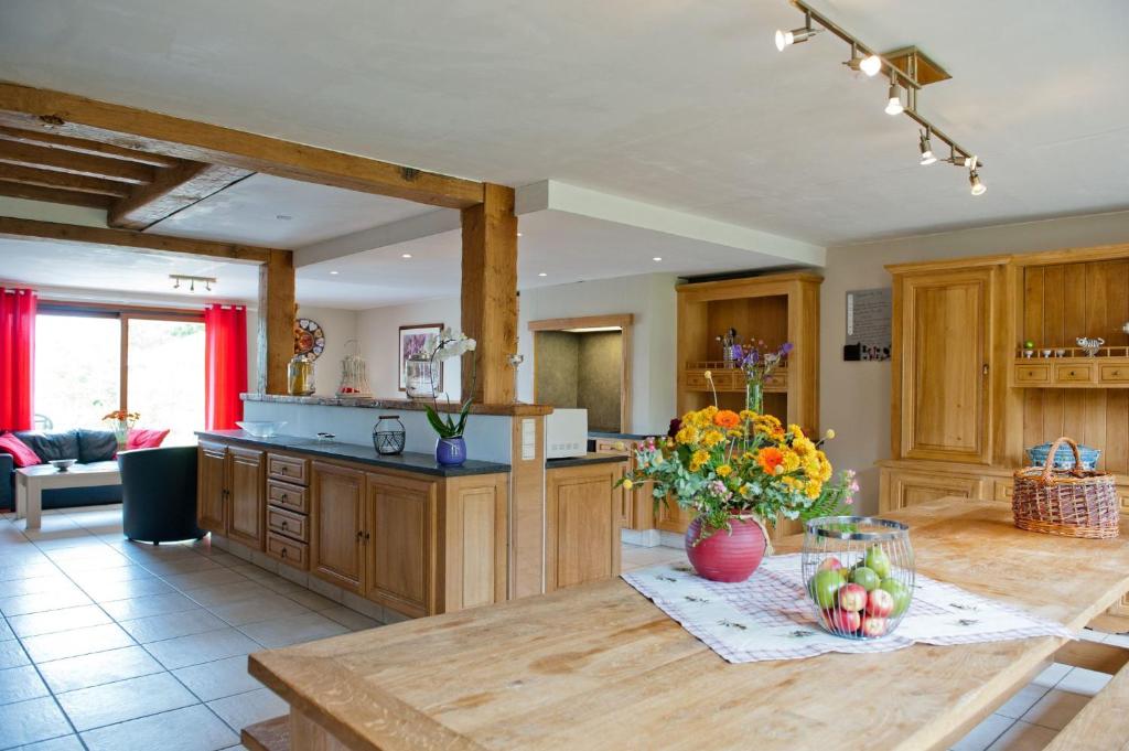 een keuken met houten kasten en een tafel met fruit erop bij Chez ELoy in Rochehaut