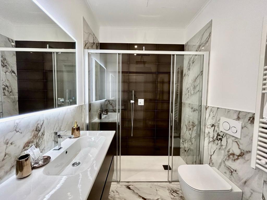 uma casa de banho com um chuveiro, um WC e um lavatório. em Da Mariella case vacanza - Bilocale Roma 104 em Sanremo