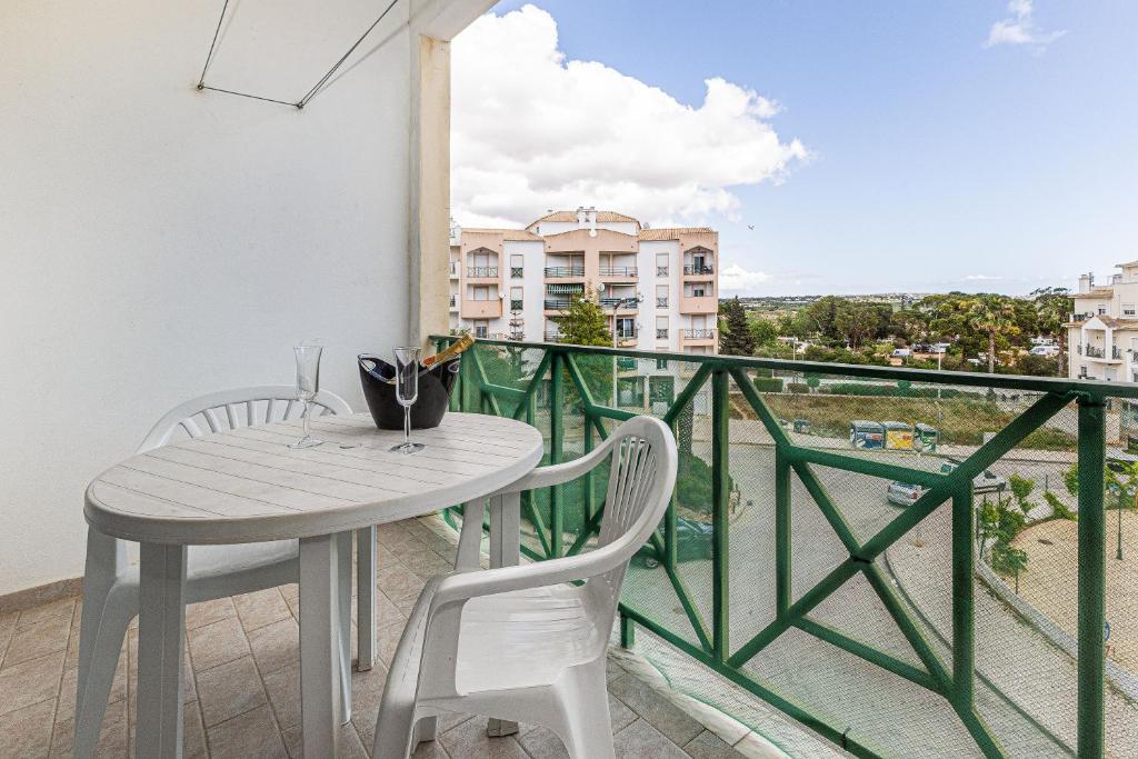 una mesa y sillas en un balcón con vistas en Sol & Mar, en Armação de Pêra