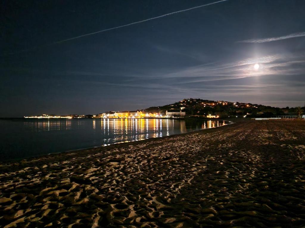 a beach at night with the moon in the sky at Studio mezzanine entier à 5min de la plage et de St tropez in Cogolin