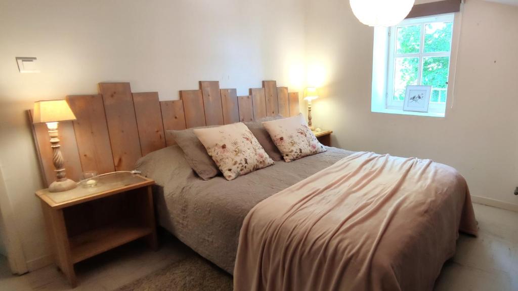 a bedroom with a bed with a wooden headboard at T3 avec sa terrasse au cœur du village médiéval in Sauzet