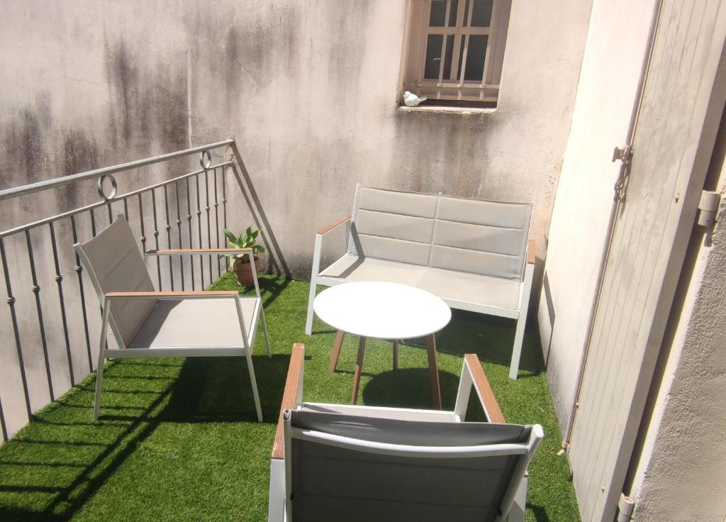balkon z 2 krzesłami i stołem na trawie w obiekcie T3 avec sa terrasse au cœur du village médiéval w mieście Sauzet