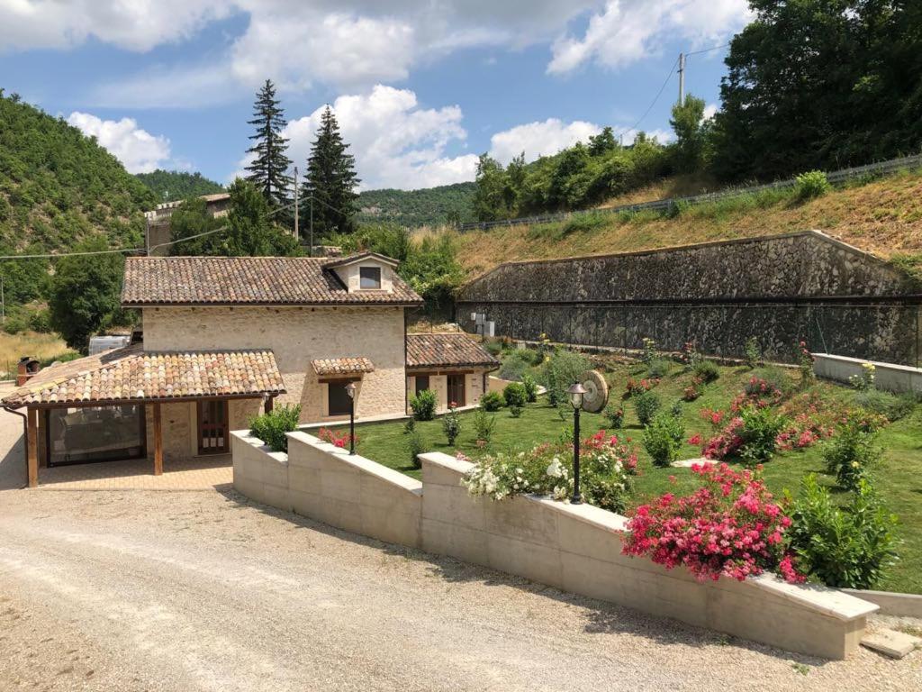 una casa con jardín en medio de una carretera en Antico Mulino di Cascia, en Cascia