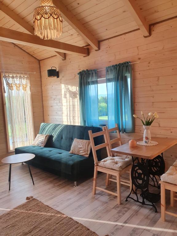 ein Wohnzimmer mit einem grünen Sofa und einem Tisch in der Unterkunft Domek Polna Cisza Bieszczady in Lesko