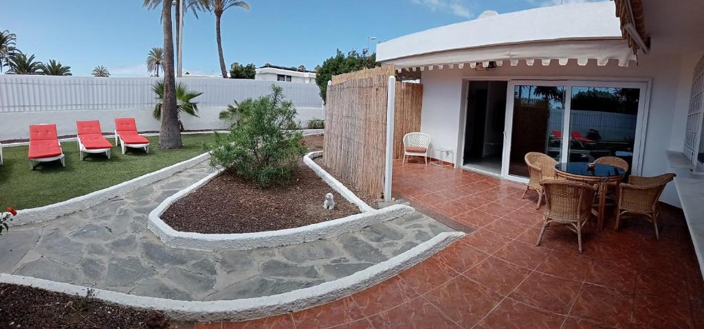 a patio with a table and chairs and a house at Granada playa! in Maspalomas