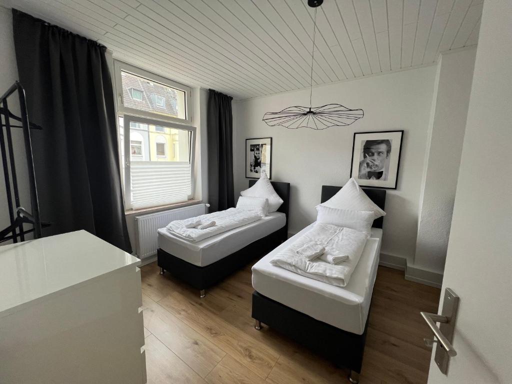Bilk Apartment في دوسلدورف: غرفة نوم بسريرين ونافذة