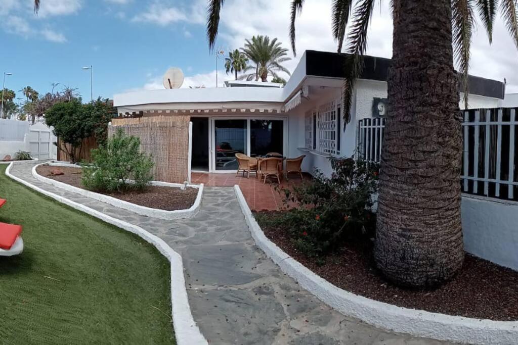 a house with a palm tree in front of it at Granada playa! in Maspalomas