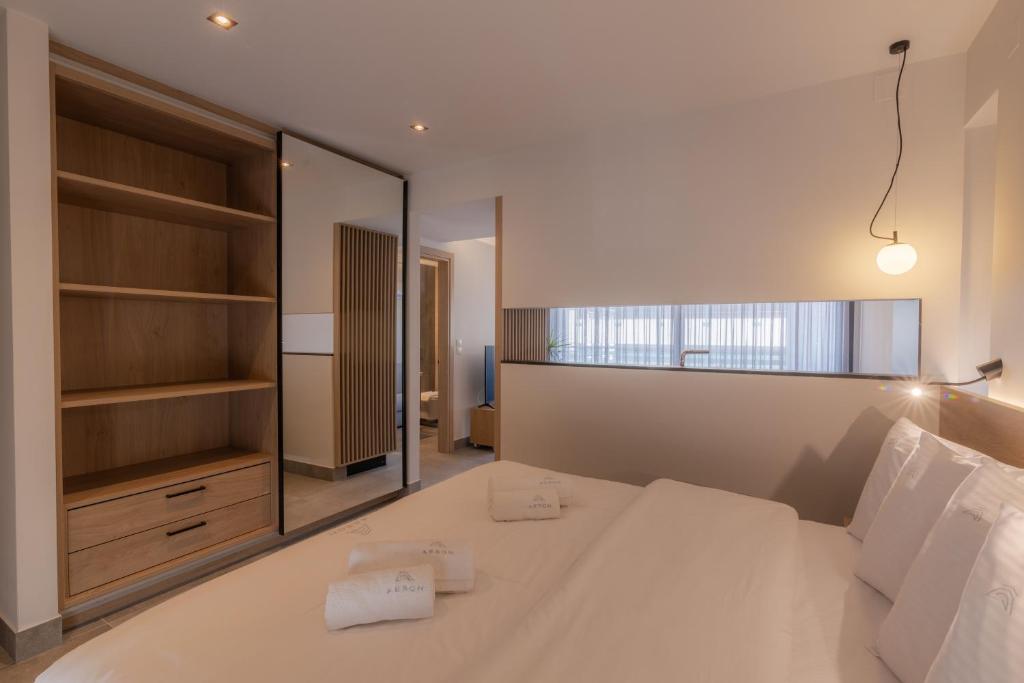a bedroom with a large white bed and a mirror at Aeson Premium Living in Volos
