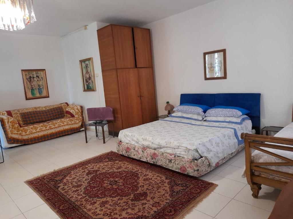 1 dormitorio con 1 cama y 1 sofá en Villa Elisa lago e monti, en Carzago della Riviera