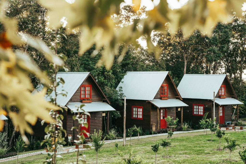 a row of wooden houses with white roofs at Locanda 65 - Serra Gaúcha in Garibaldi