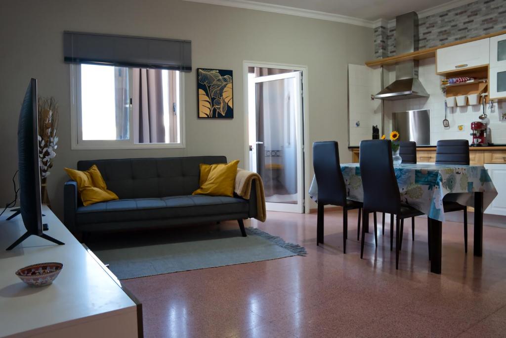 Una sala de estar con un sofá y una mesa de comedor. en BrisaMarTelde, en Telde