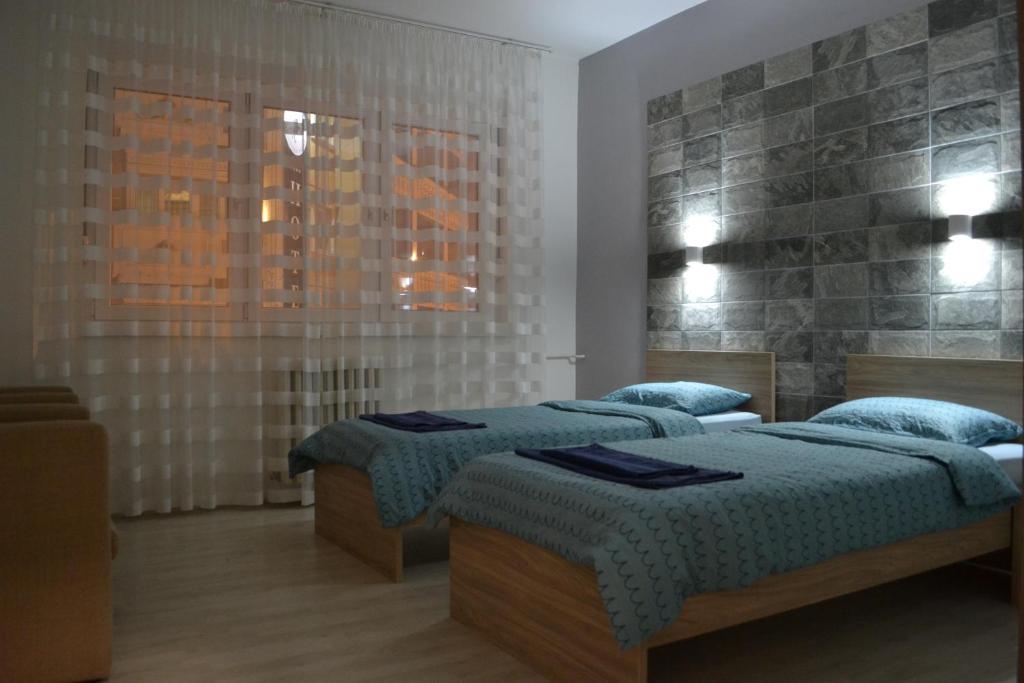a bedroom with three beds and a window at Lazarus Apartment in Skopje