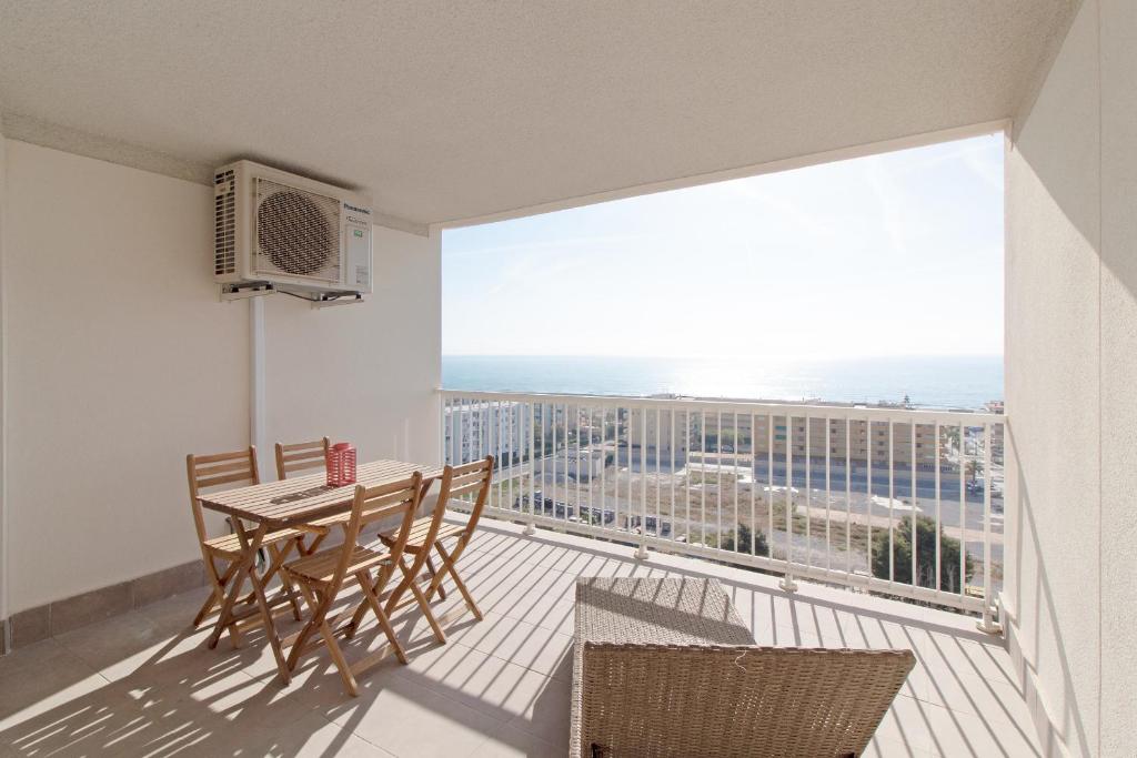 uma varanda com mesa e cadeiras e vista para o oceano em Global Properties, Apartamento de 2 habitaciones con terraza y vistas al mar em Canet de Berenguer