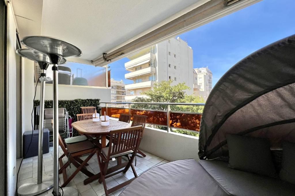 une chambre avec un balcon avec une table et des chaises dans l'établissement Beautiful flat with terrace near Croisette, à Cannes