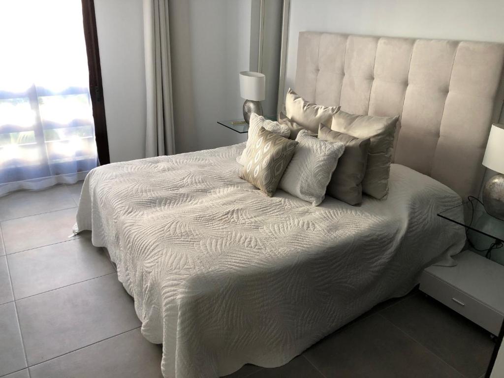 - un lit blanc avec des oreillers dans la chambre dans l'établissement Enjoy Spain - La Maestranza, à Marbella